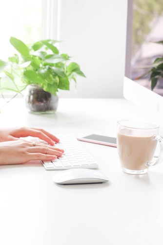 plant in office with woman at computer and coffee 